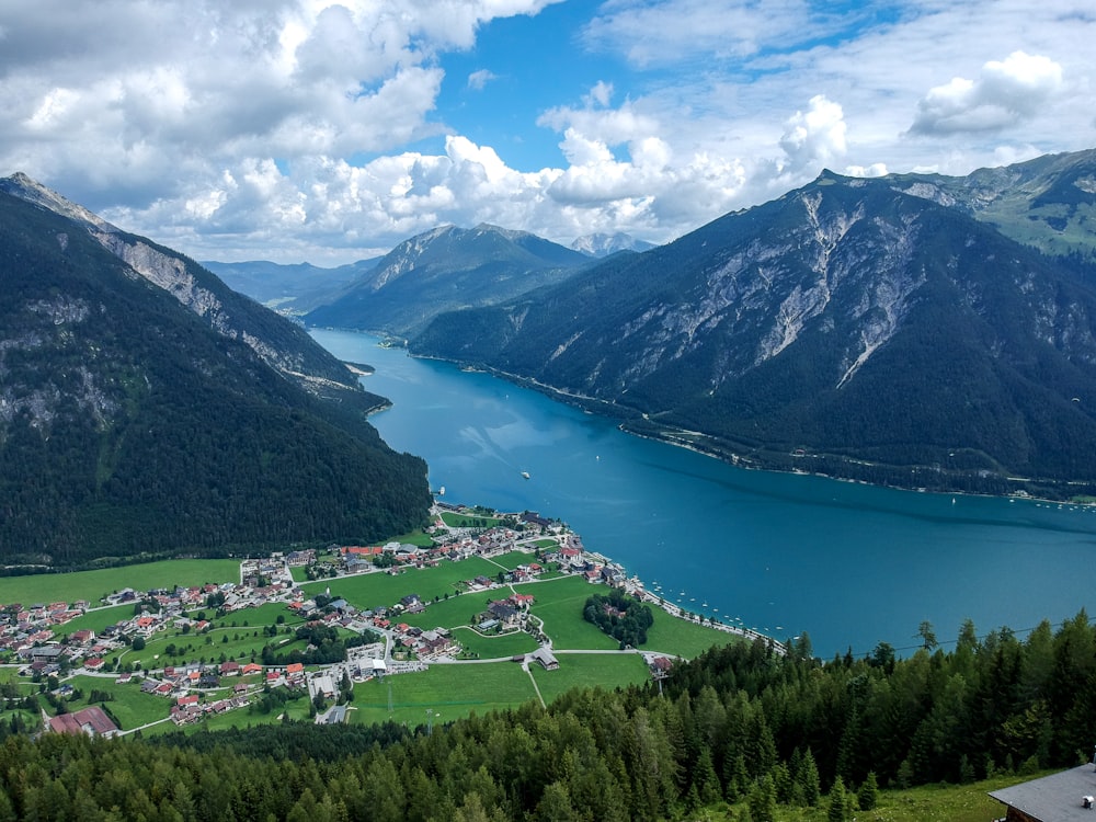 Montagnes vertes près du plan d’eau sous le ciel bleu pendant la journée