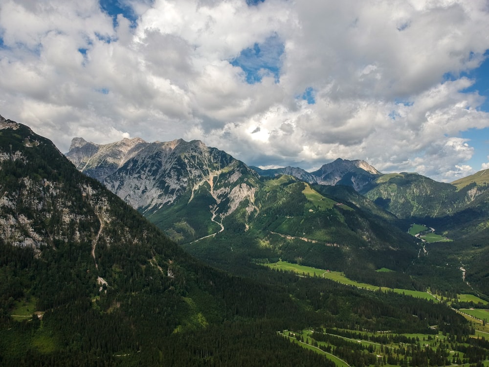 green trees on mountain under white clouds during daytime