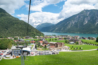A professional taxi driver assisting a passenger with luggage in a scenic alpine village.