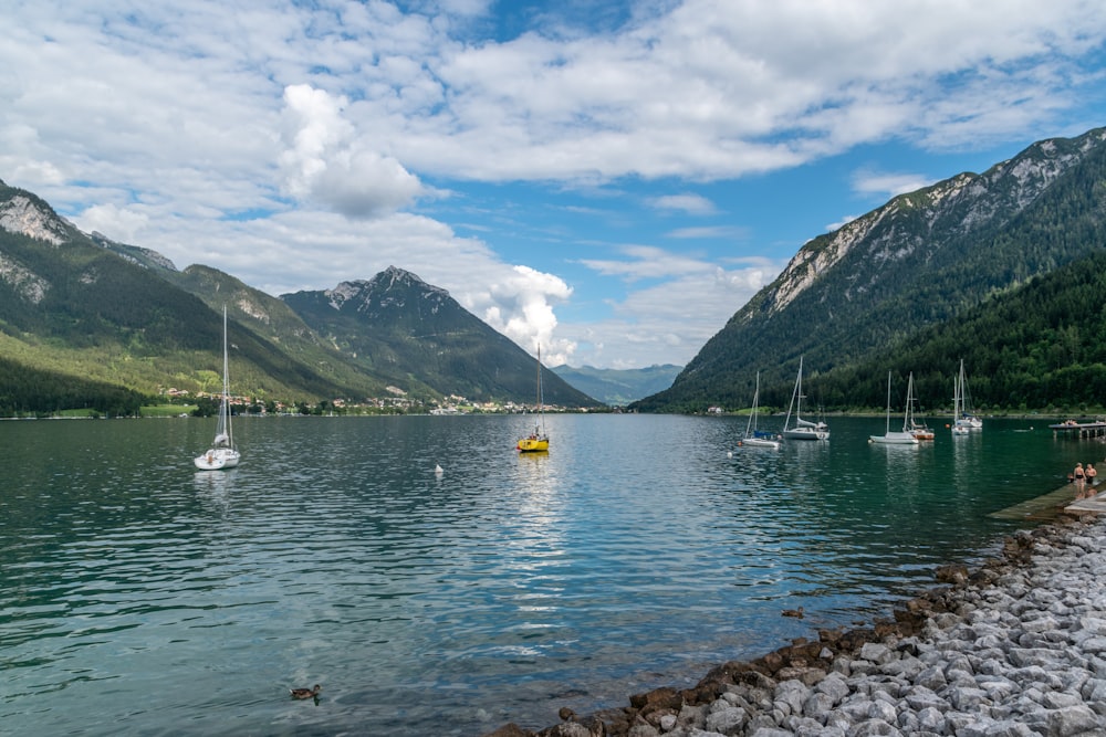 Bateau blanc sur l’eau près de la montagne pendant la journée