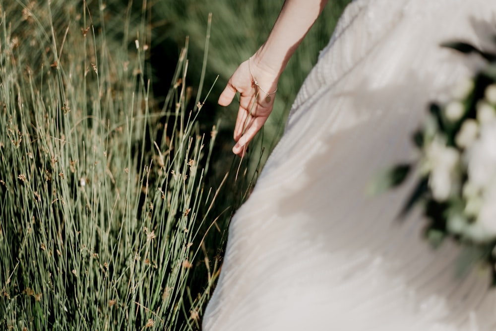 woman in white dress holding green grass