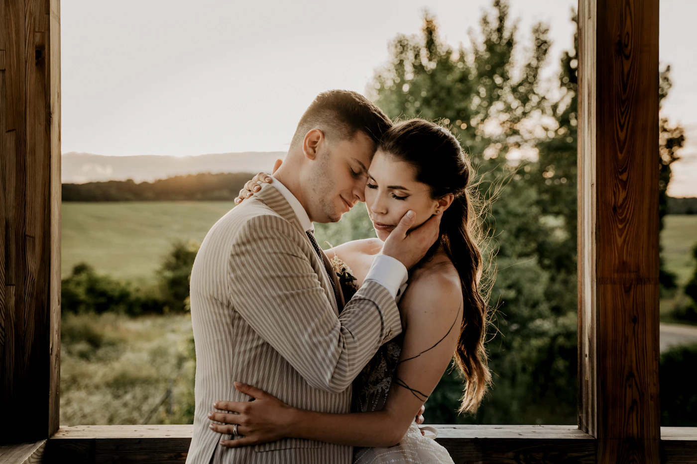 Couple in white wedding attire kissing together outdoors