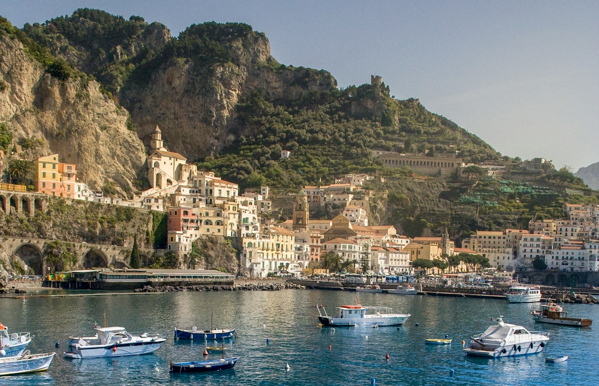 view of boats in amalfi harbor and town