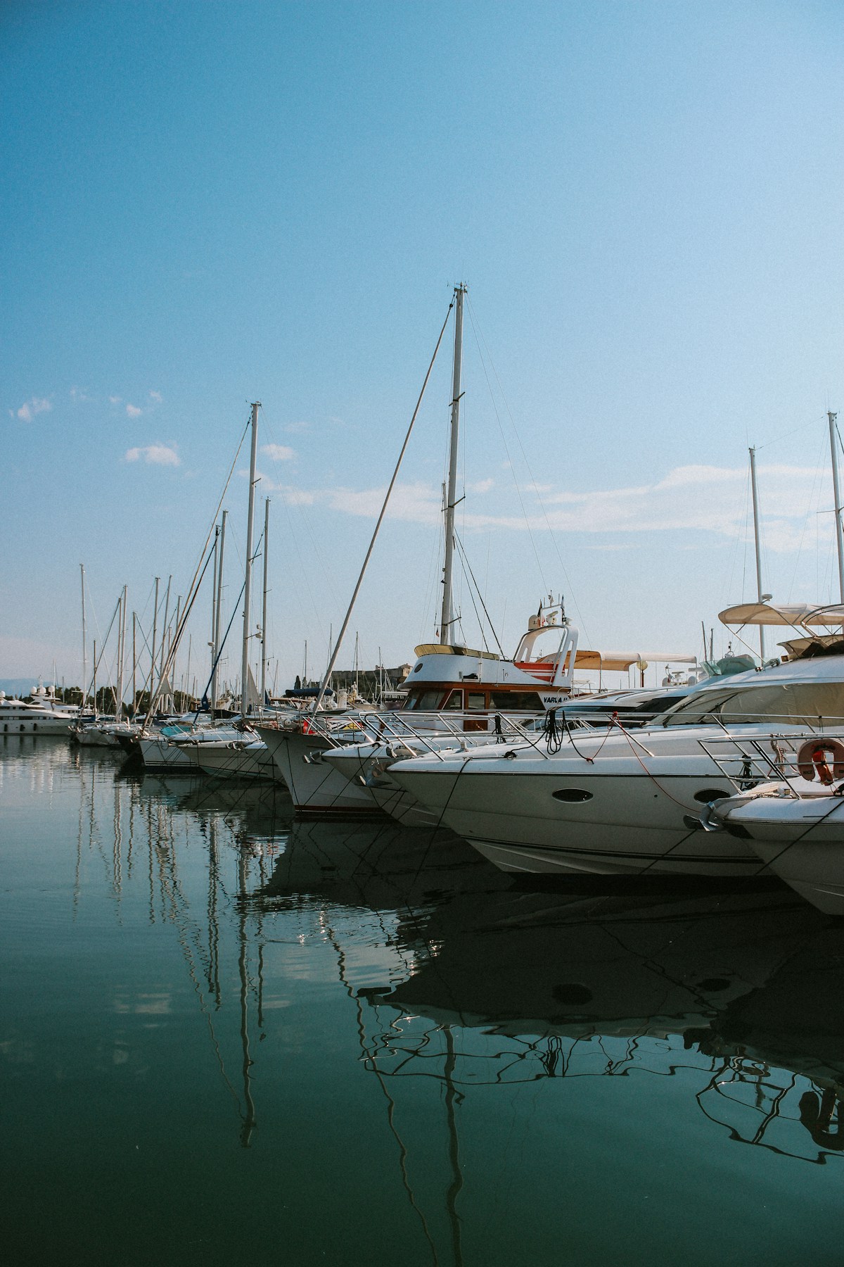 Boats moored at a coastal marina on a bright day