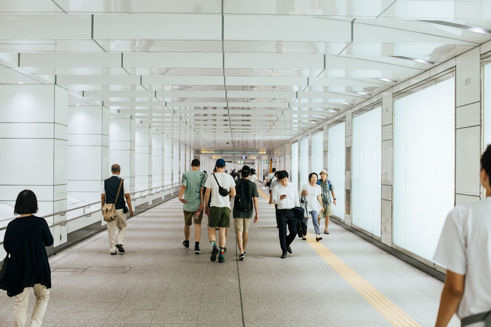 people walking on white hallway