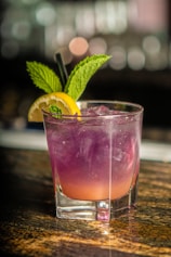 clear drinking glass with pink liquid and lemon