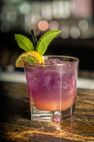 clear drinking glass with pink liquid and lemon