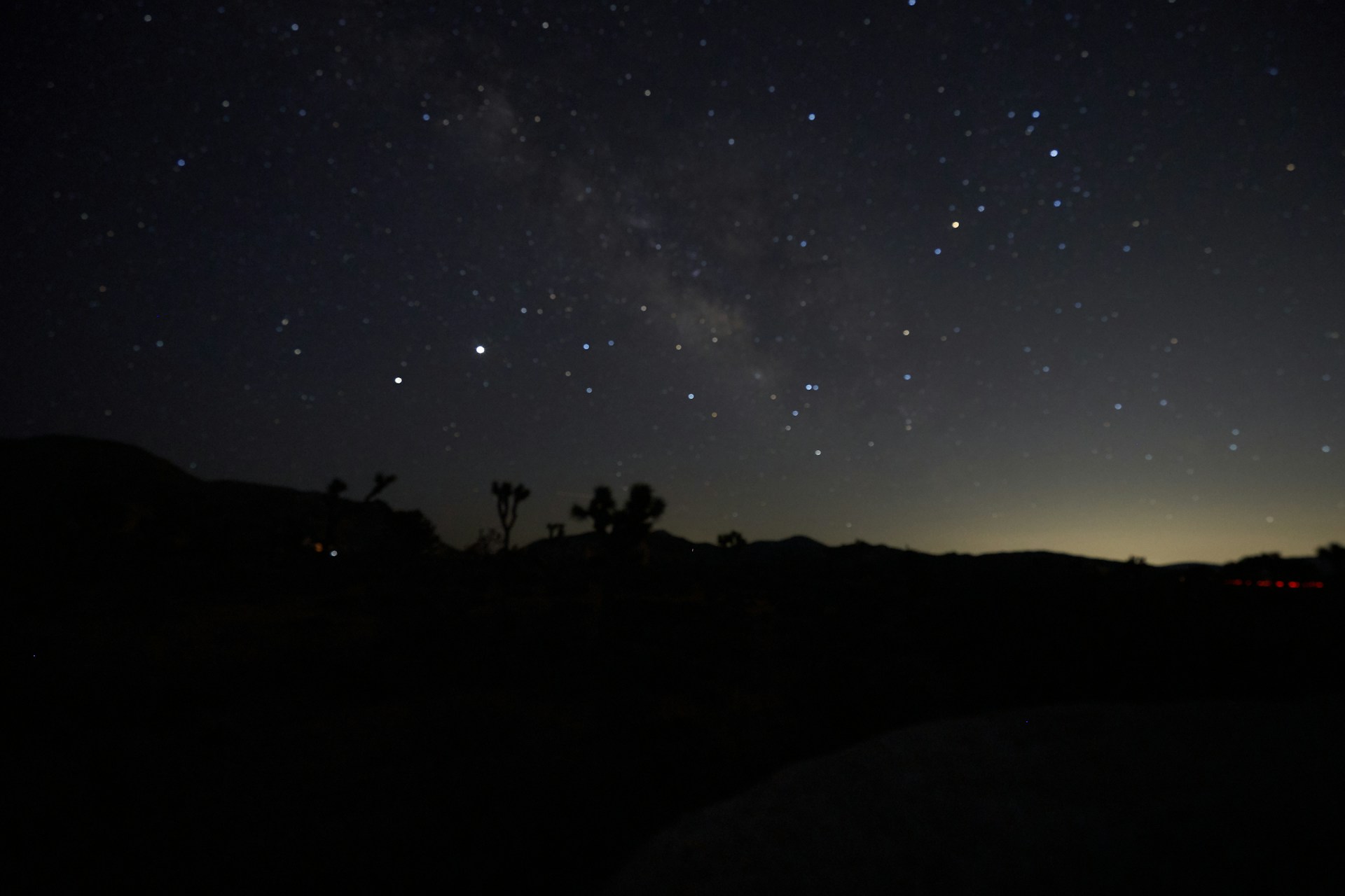 silhouette of people on hill under starry night