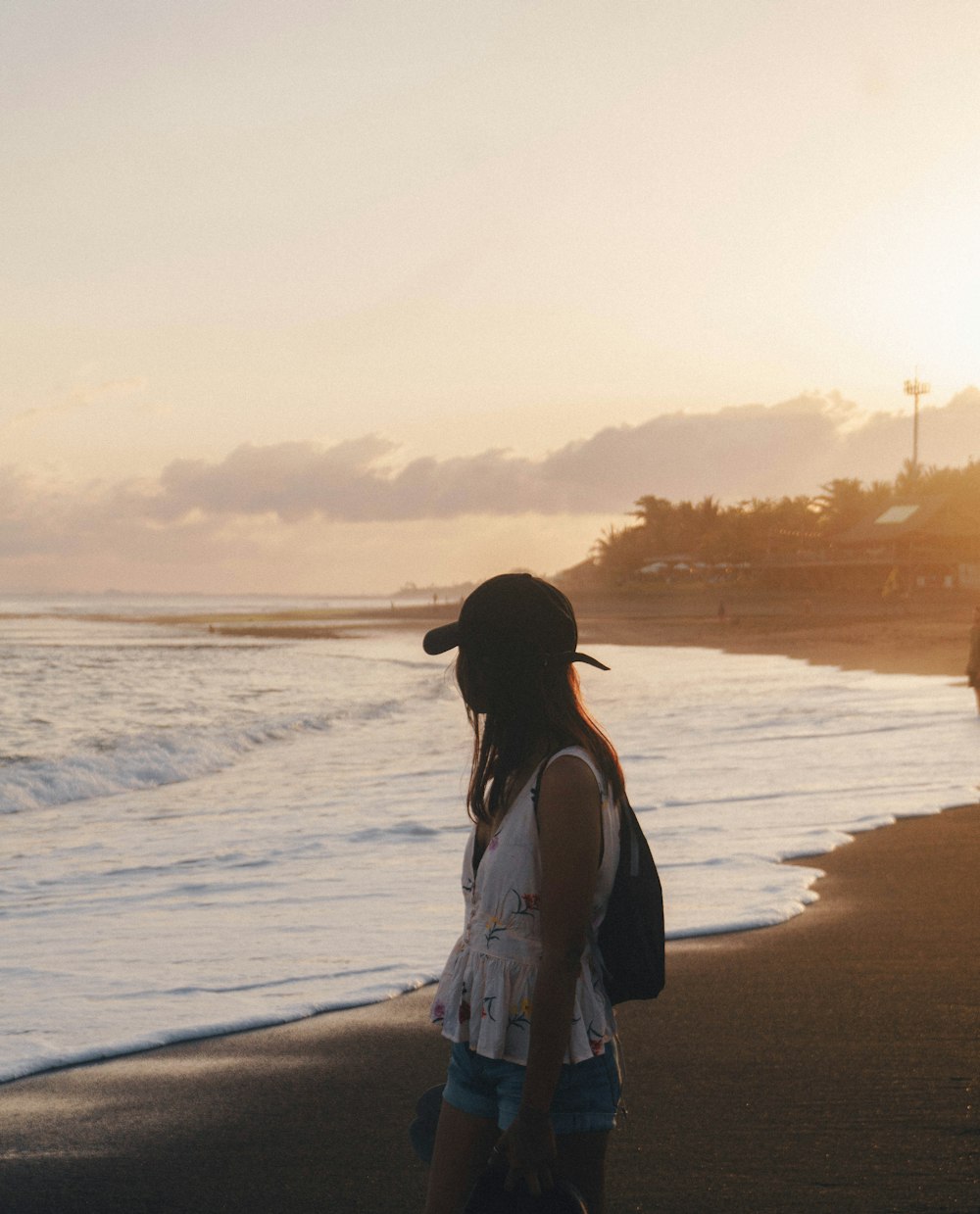 woman in white dress standing on beach during sunset