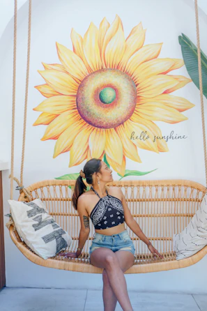 A sunlit porch swing with soft Sunbrella cushions surrounded by blooming flowers.