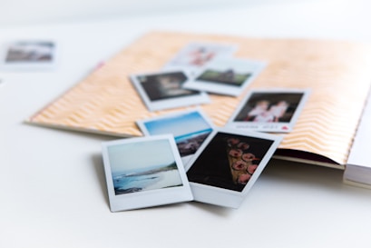 Scattered polaroid-style cards with handwritten captions, laid out on textured paper.
