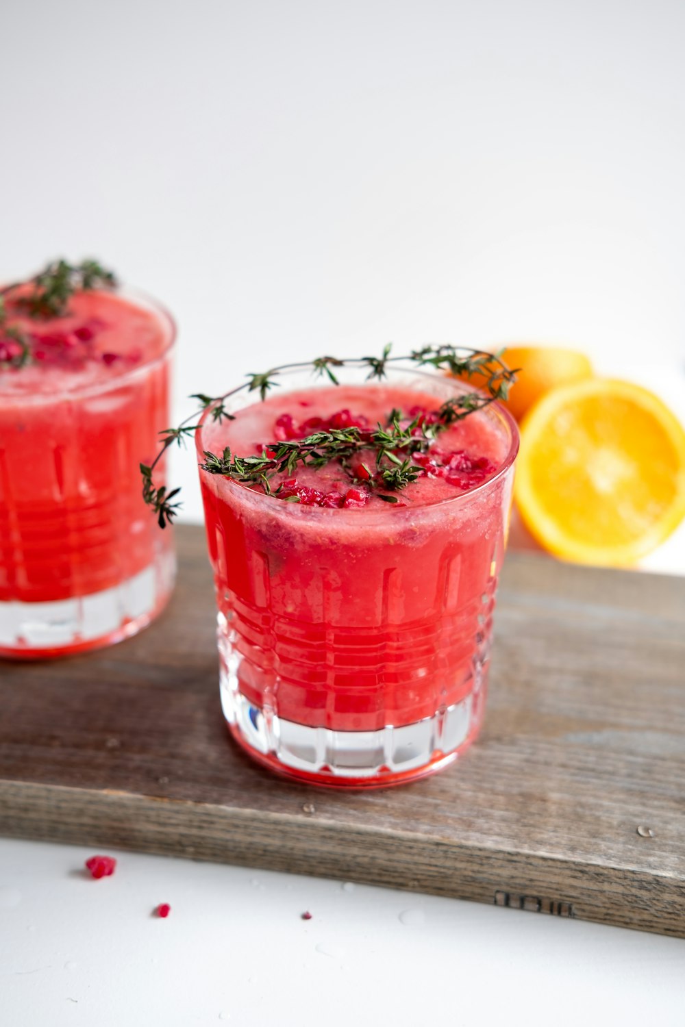 Bicchiere trasparente con liquido rosso e limone a fette