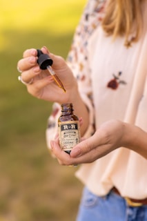 person holding brown glass bottle