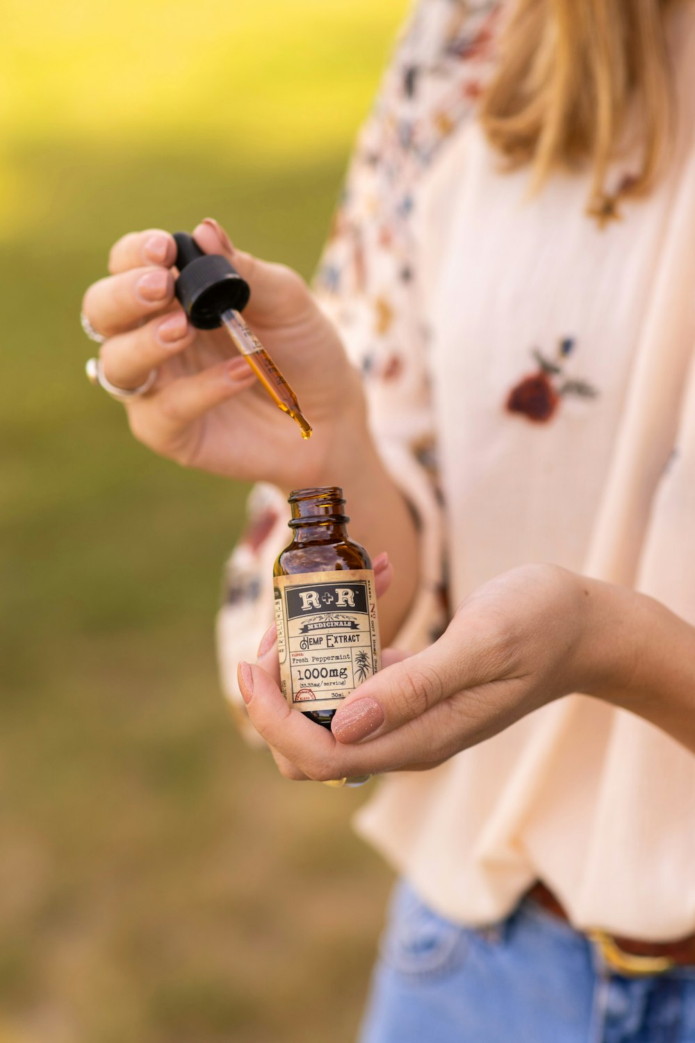 person holding brown glass bottle