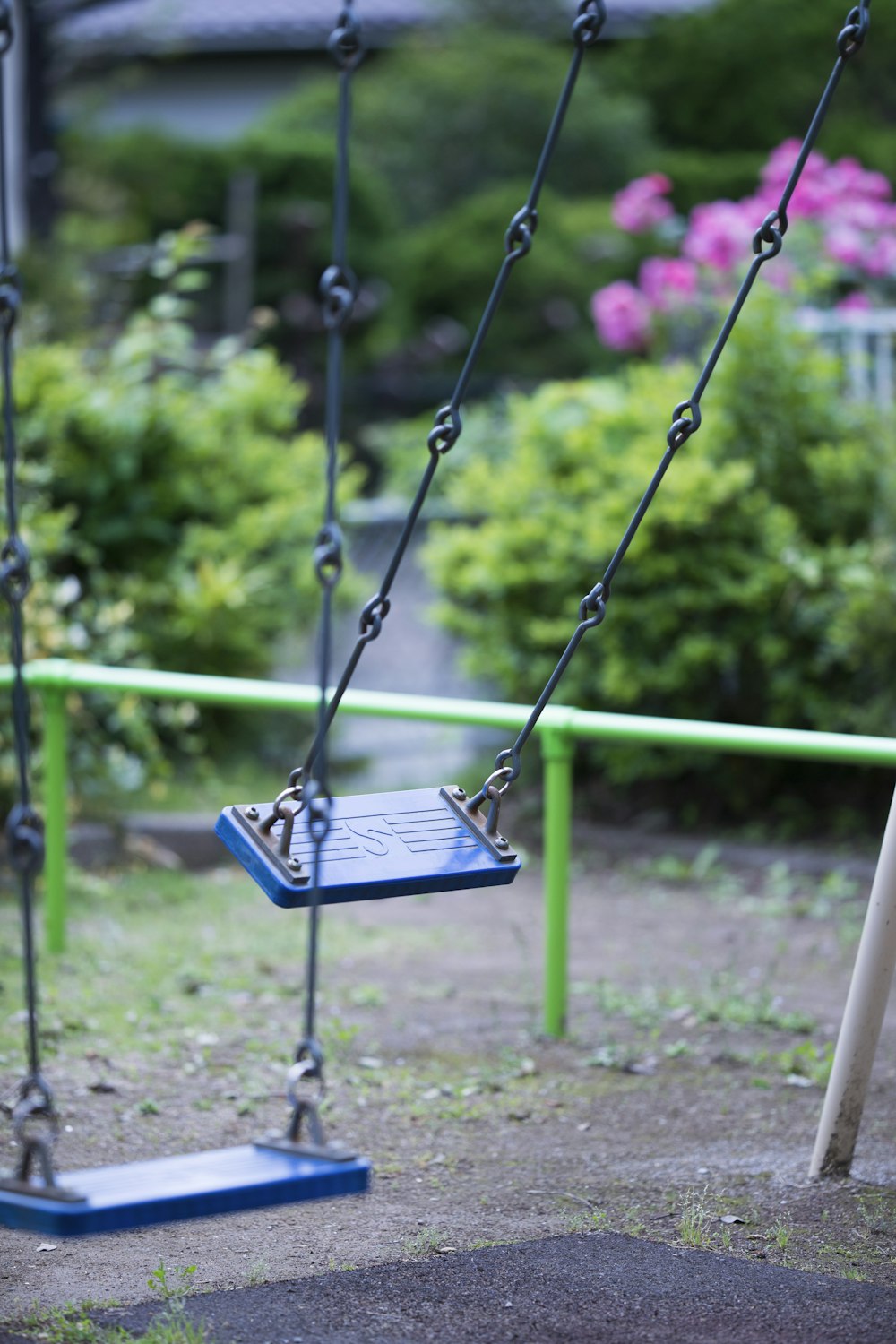 black metal swing on green grass field during daytime