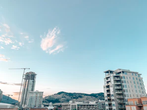 Empty land plot ready for development with a clear blue sky and distant cityscape