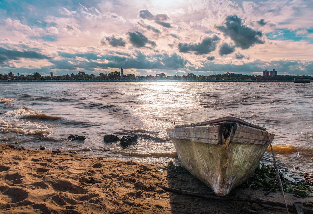 white boat on sea shore during daytime