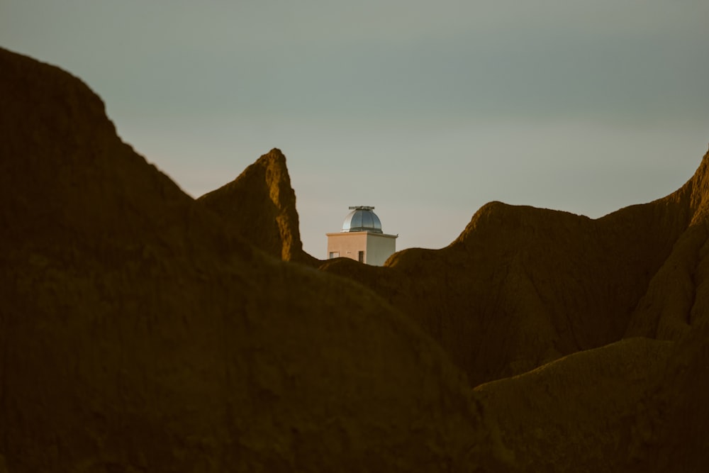 edifício de concreto branco no topo da montanha marrom