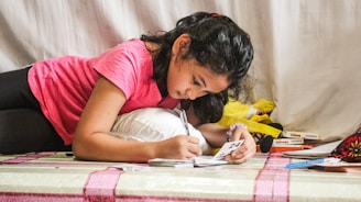 woman in red t-shirt writing on white paper