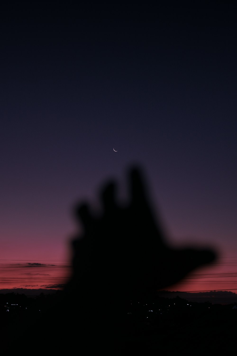 silhouette of person doing peace sign during sunset