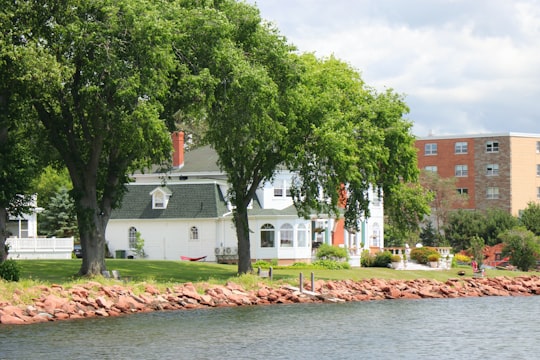 green tree near white concrete house during daytime in Charlottetown Canada