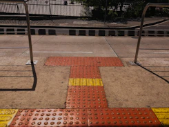 Installation team applying tactile flooring in a public park pathway.