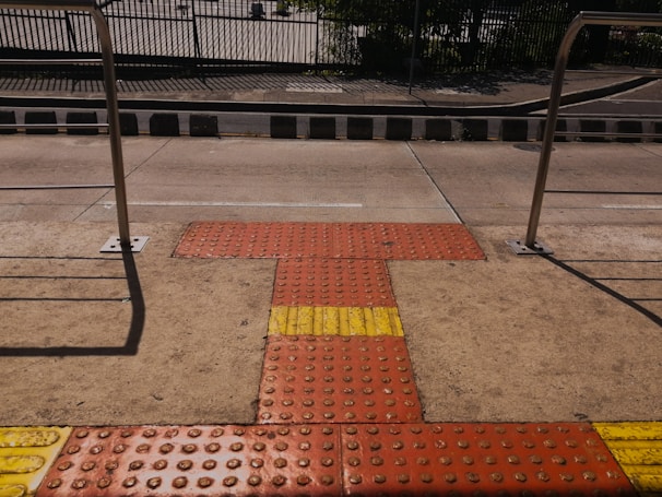 Close-up of tactile paving guiding visually impaired students along a campus walkway