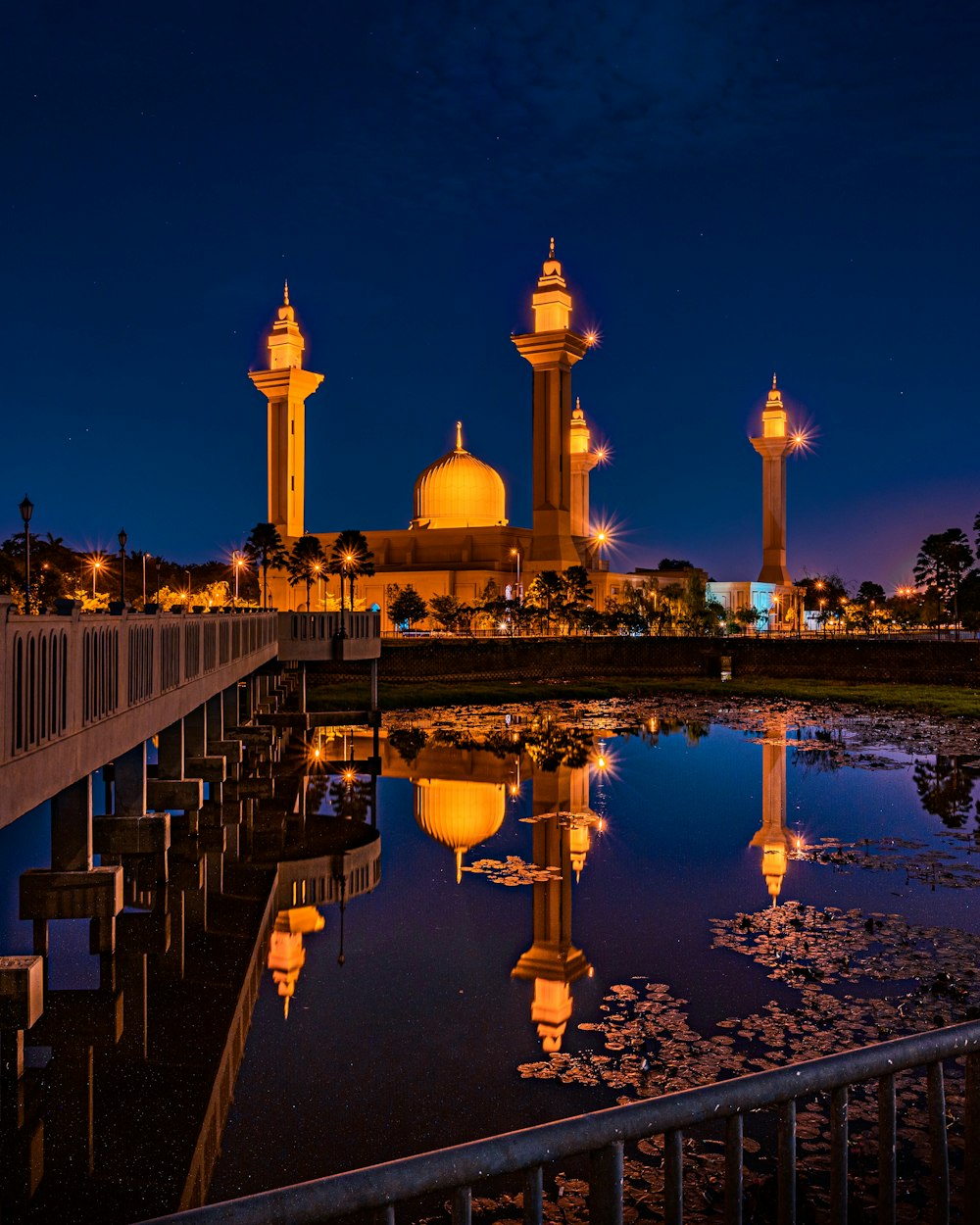 people walking on bridge near white concrete building during night time