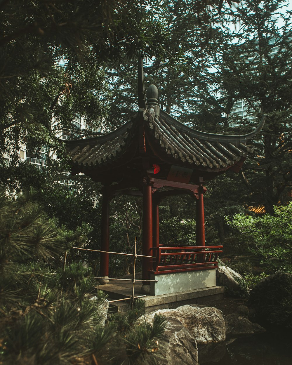 gazebo in legno marrone circondato da alberi verdi durante il giorno