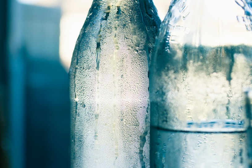 Close-up of a glass bottle filled with fresh, creamy kefir, condensation droplets visible on the surface.