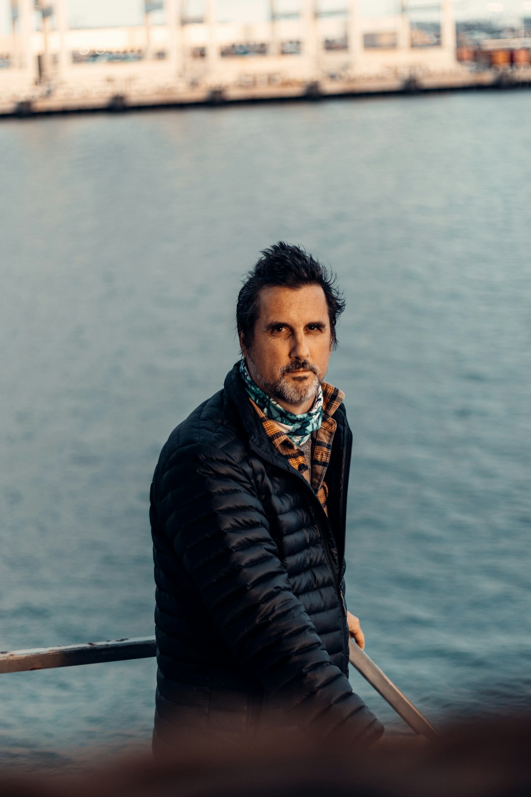 man in black jacket standing near body of water during daytime