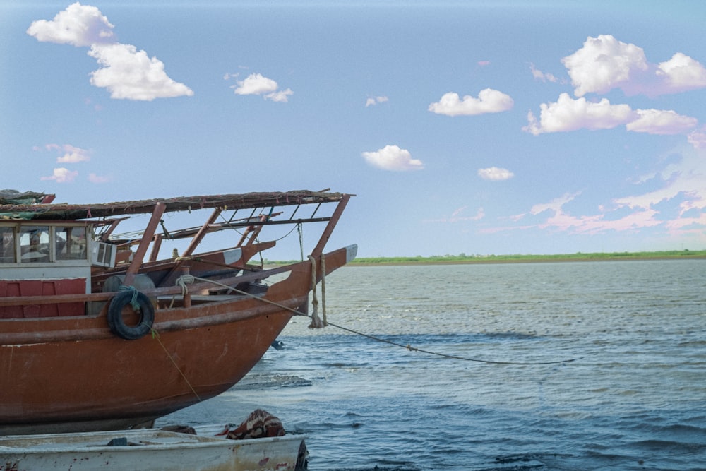 brown boat on sea shore during daytime