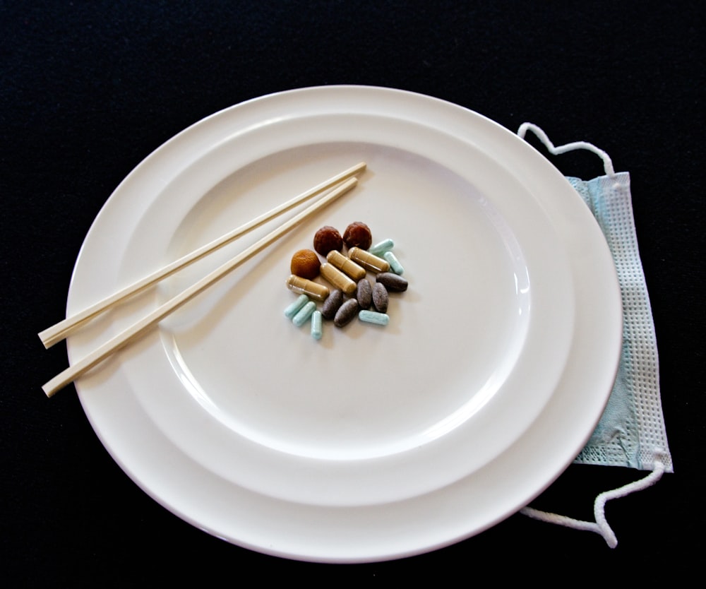 white ceramic round plate with chopsticks