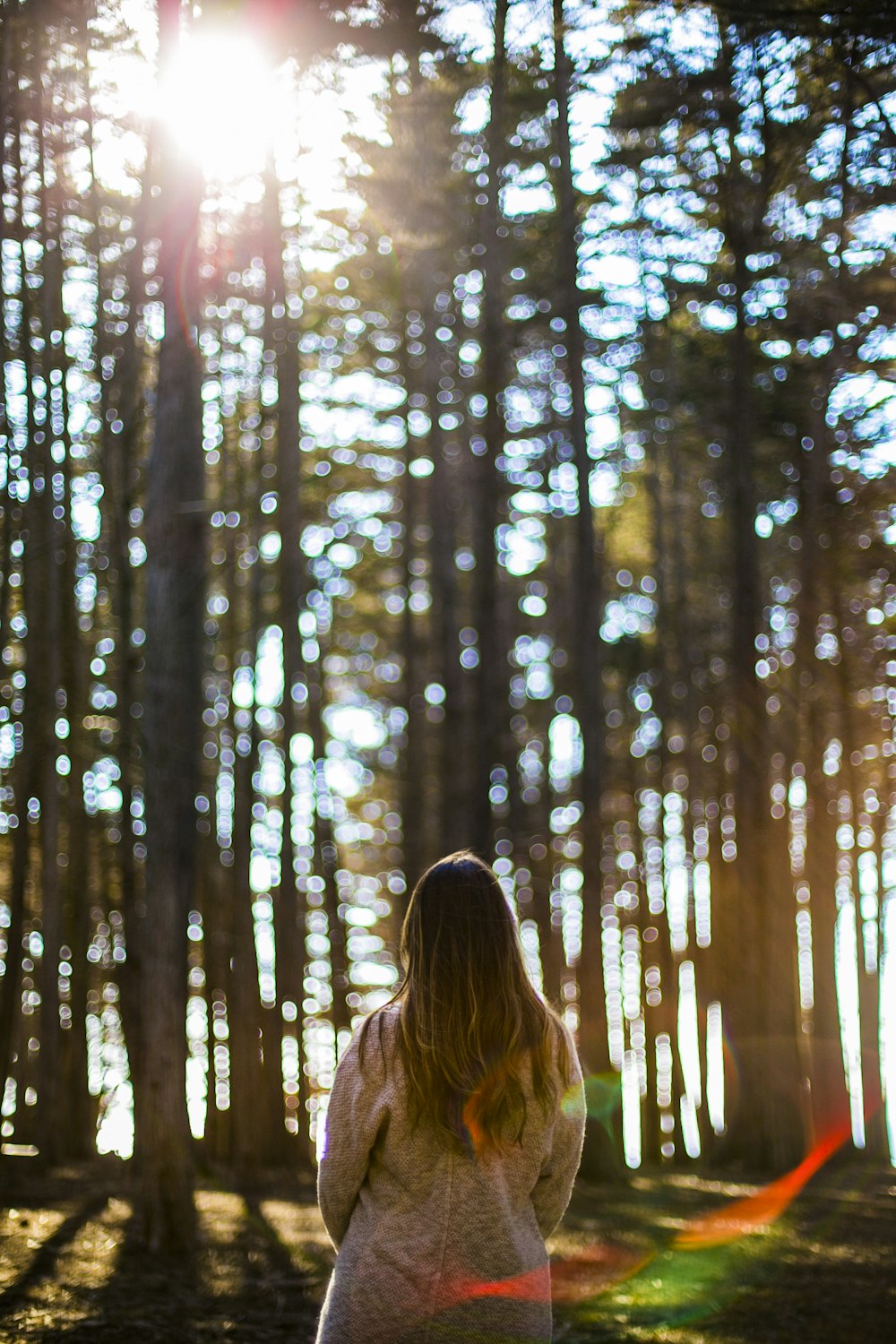 woman in white shirt standing in front of trees during daytime