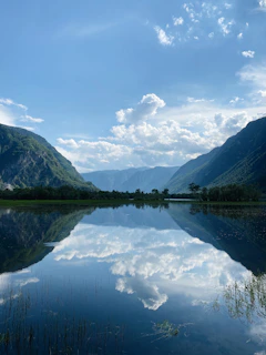 green mountains beside lake under blue sky during daytime