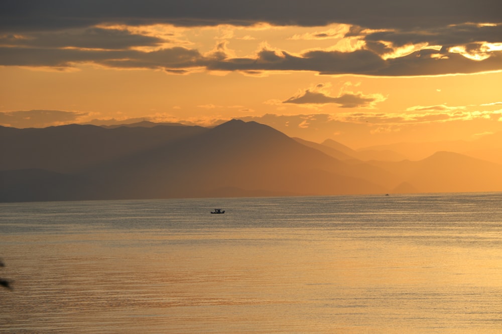 body of water near mountain during daytime