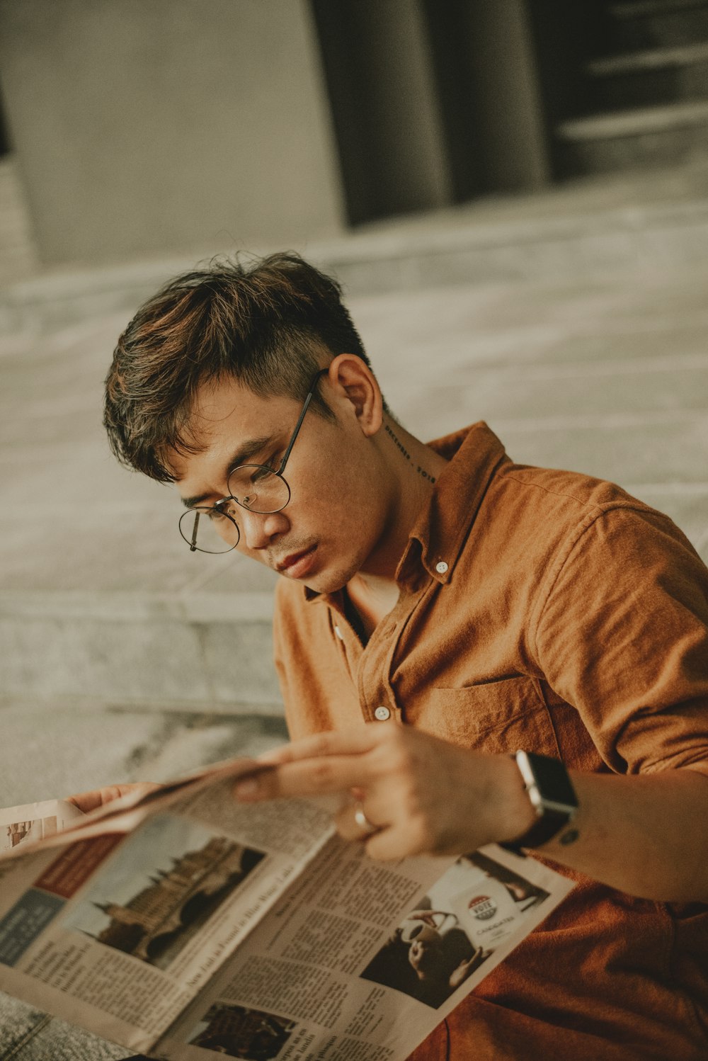 man in brown button up shirt holding white tablet computer