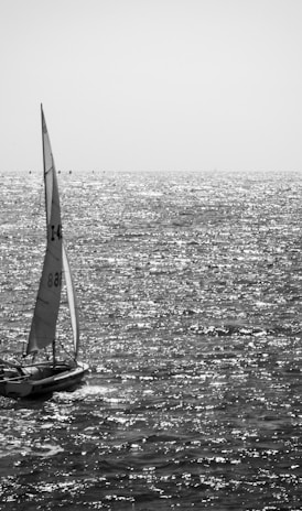 grayscale photo of sailboat on sea