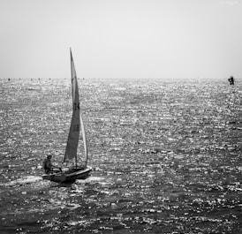 grayscale photo of sailboat on sea