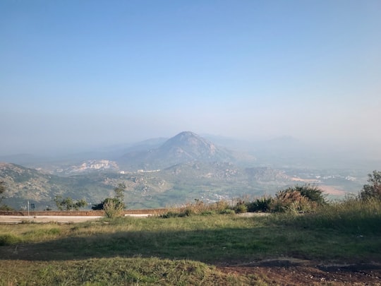 green grass field near mountain under blue sky during daytime in Bengaluru India