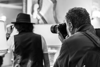 man in black hat taking photo