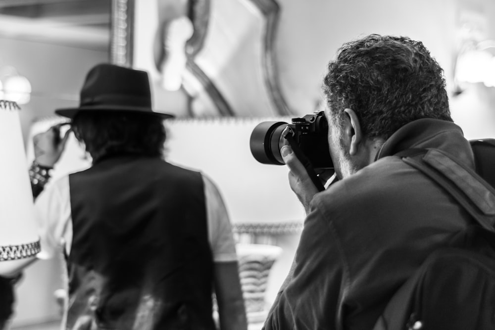 man in black hat taking photo