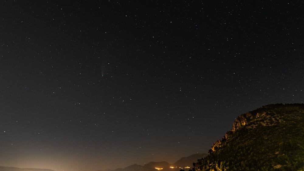 silhouette of mountain under starry night