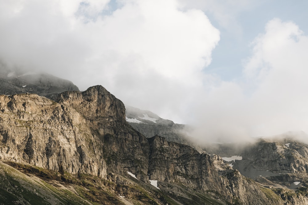 brown rocky mountain under white clouds during daytime