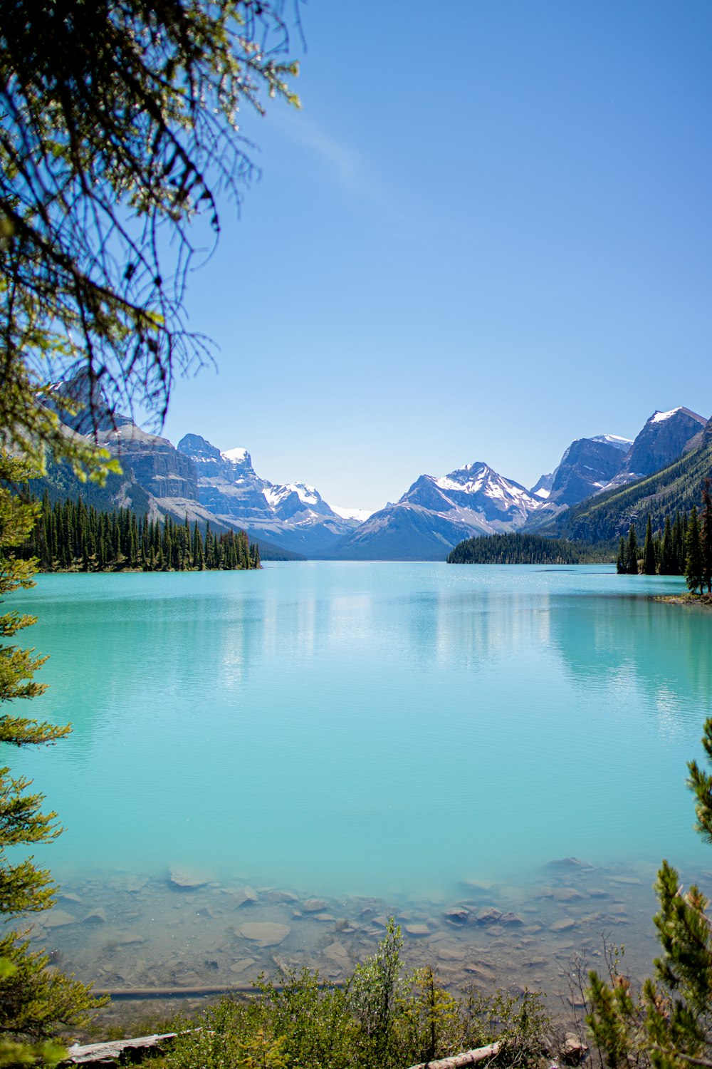 昼間は青空の下、緑の木々と山々に囲まれた湖