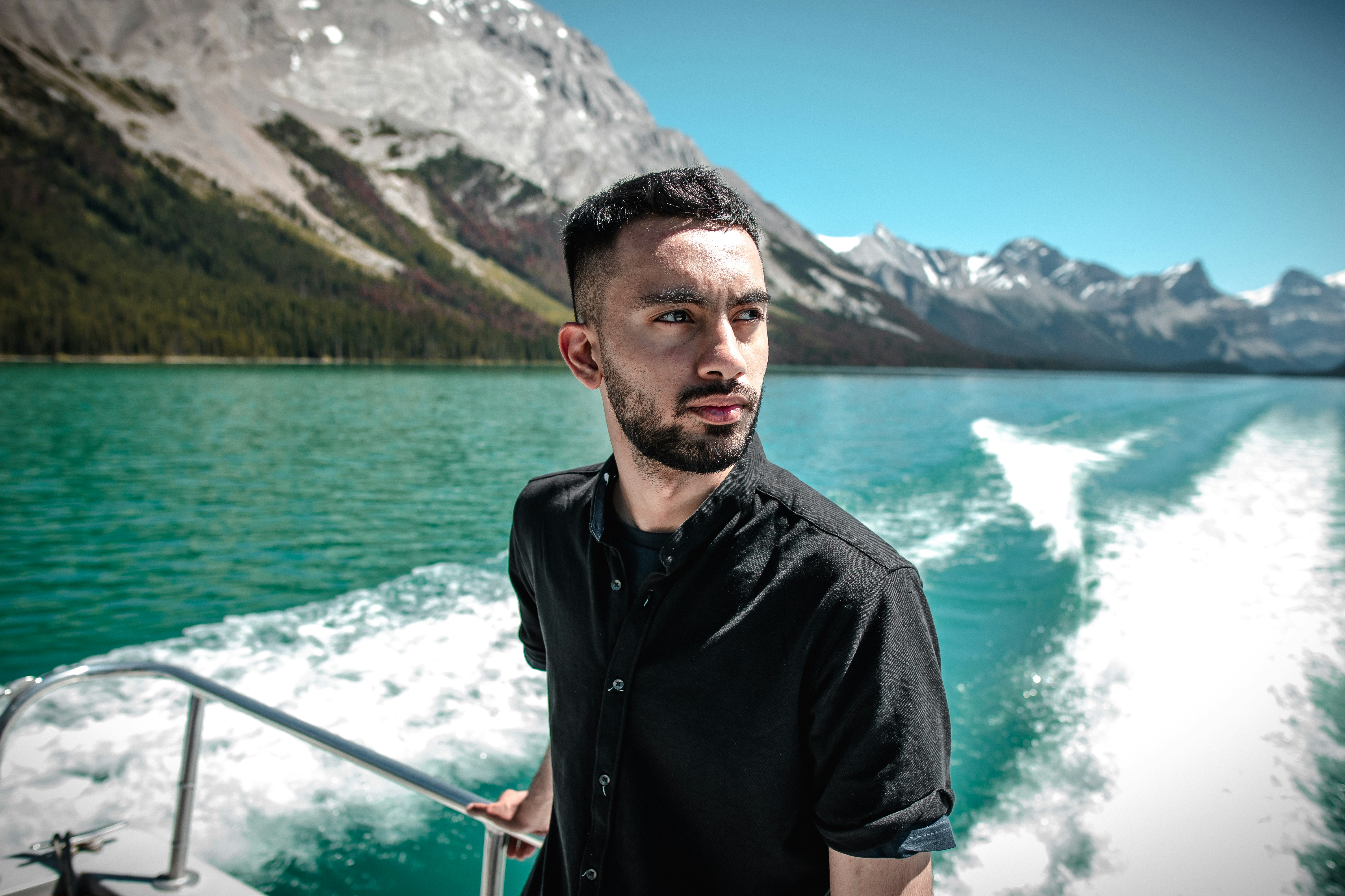 man in black button up shirt standing near body of water during daytime