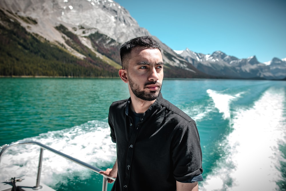 man in black button up shirt standing near body of water during daytime