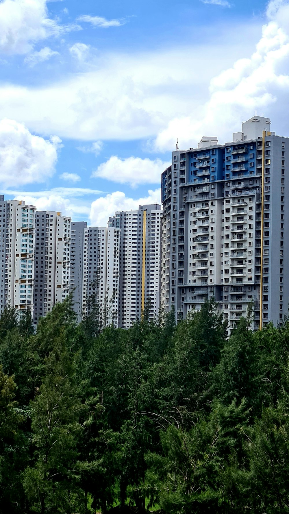 white concrete building near green trees under blue sky during daytime