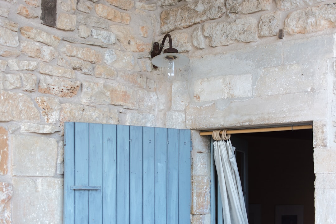 blue wooden door on brown brick wall