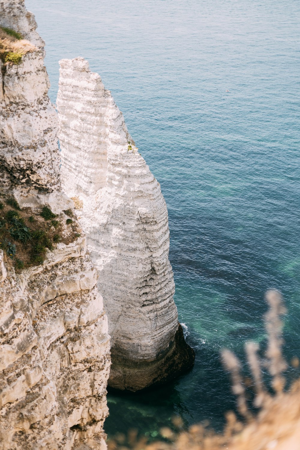 Montagne Rocheuse Blanche au bord de la mer bleue pendant la journée